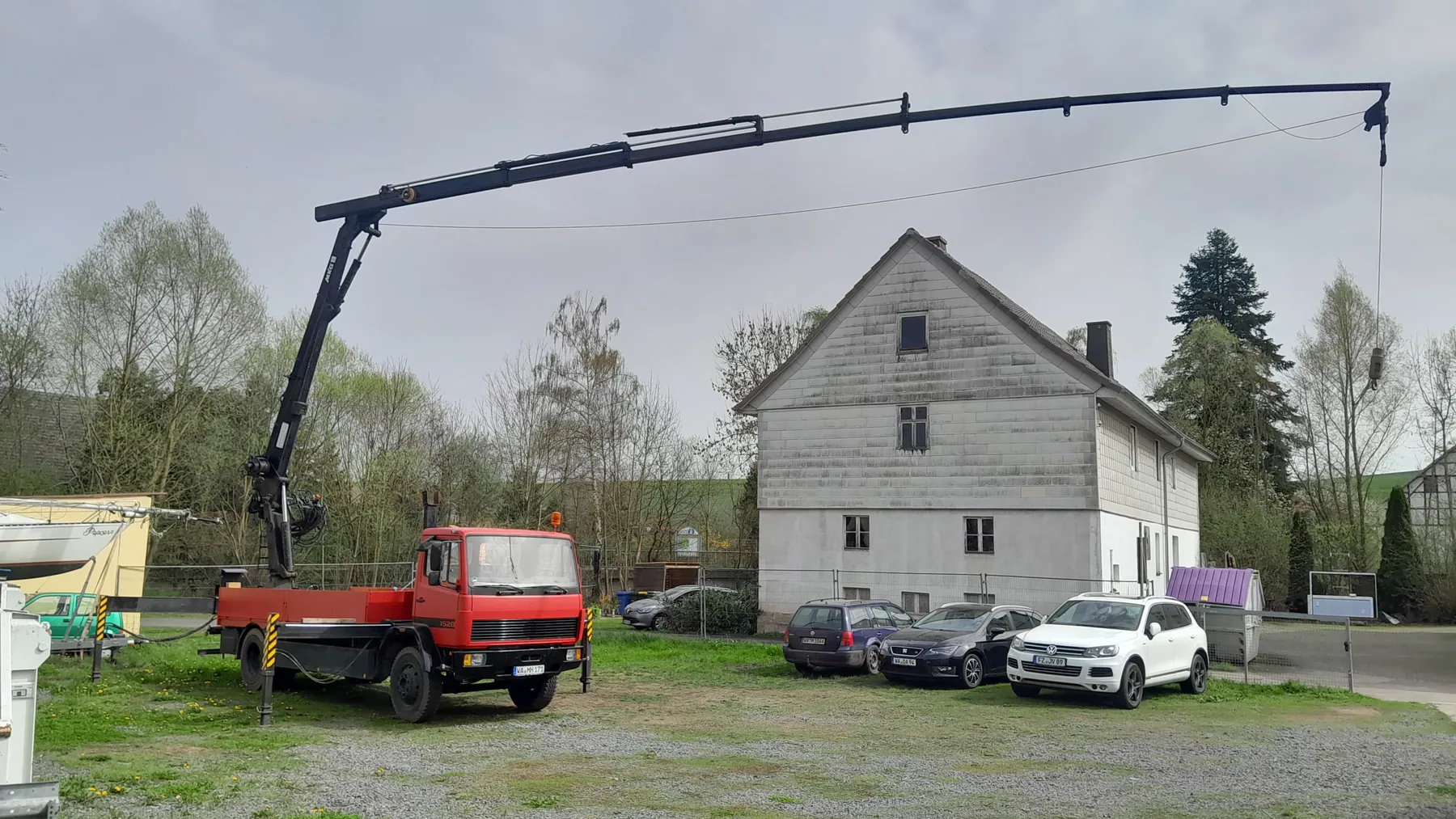 Kompakter Autokran Mercedes-Benz 1520 mit MKG HMK 175 im Einsatz an einem Wohnhaus
